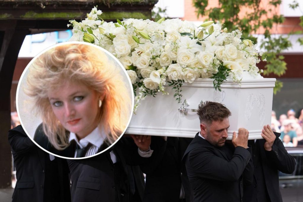 Bonnie Tyler durante una actuación, mirando a la cámara con su característica melena rubia.