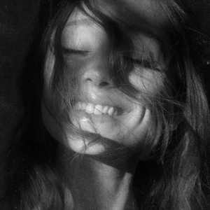 Portada del álbum 'petal' de Ariana Grande, con una imagen en blanco y negro de la artista sonriendo.